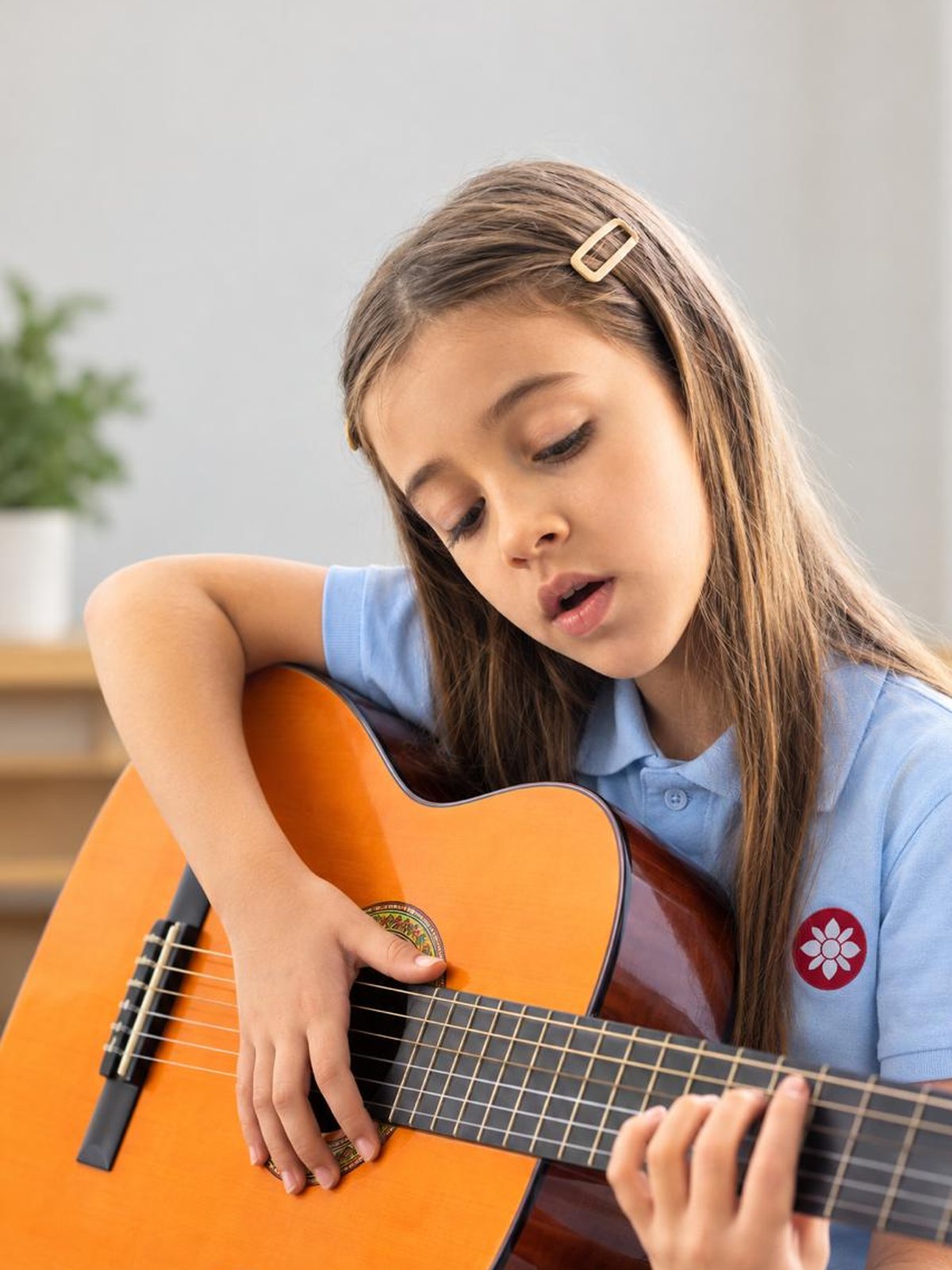 Aluna a cantar enquanto toca guitarra